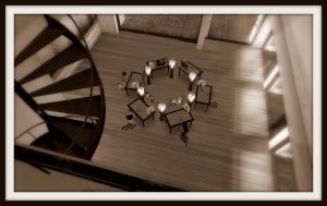 View from the Gallery Xue / NYC 2nd floor looking down into the main space where a number of desk or altar prayer stations are in a circle. Each features someone wronged in the past.